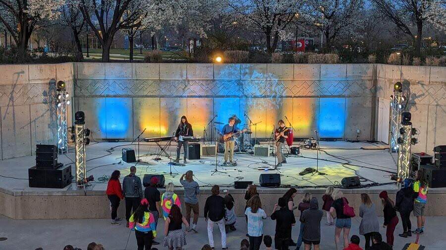 Community concert with a crowd and colorful stage lighting