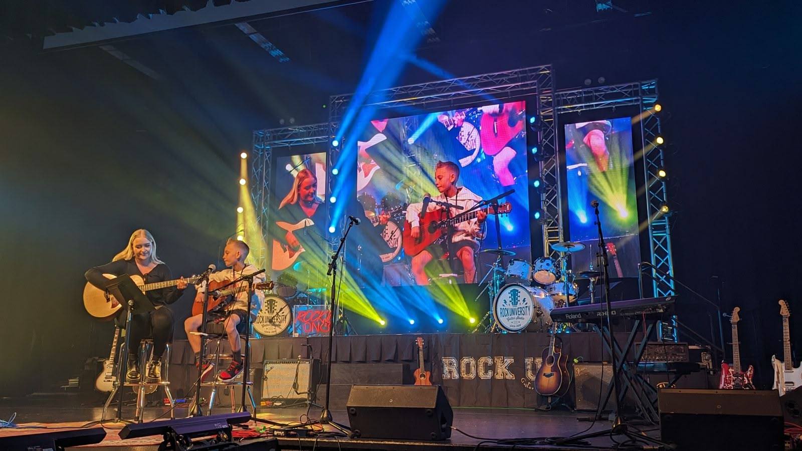 A student band under full concert lighting on the Rock U Live stage